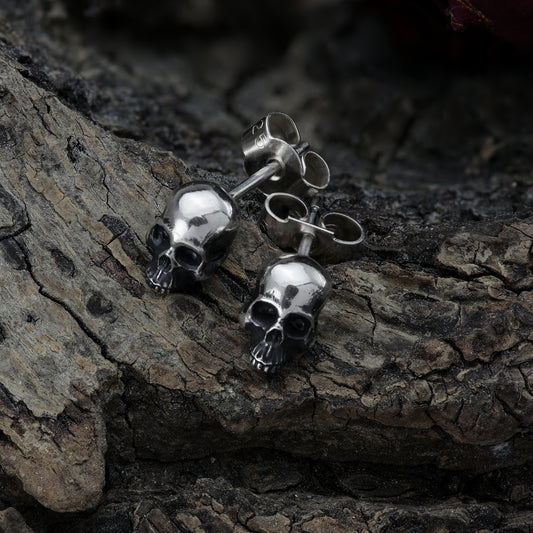 Close-up of sterling silver skull earring revealing intricate details.