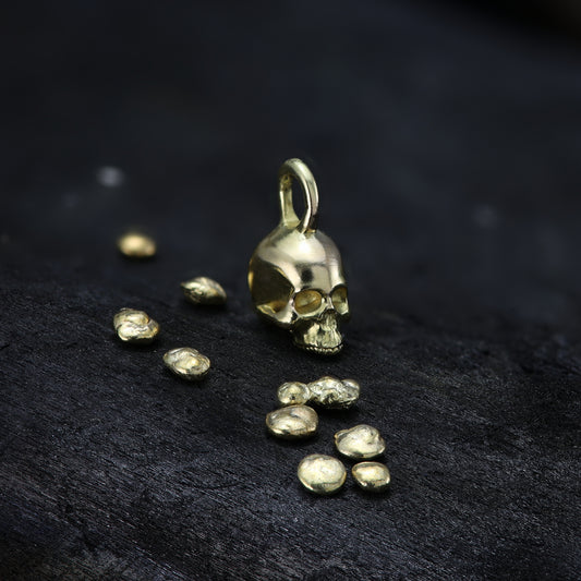 alt="18-carat gold miniature skull pendant showcasing intricate details and craftsmanship"