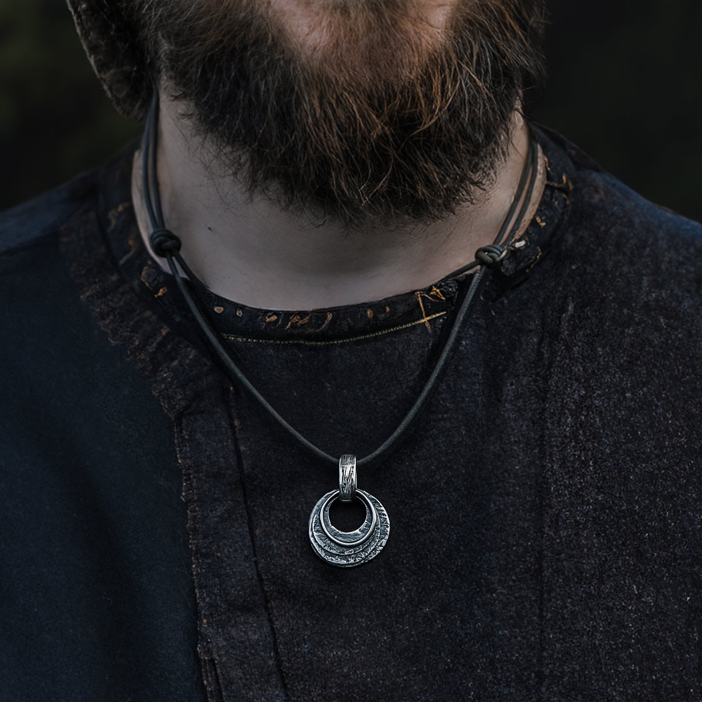 Round silver pendant with textures reminiscent of Viking art, crafted for the modern Pagan.