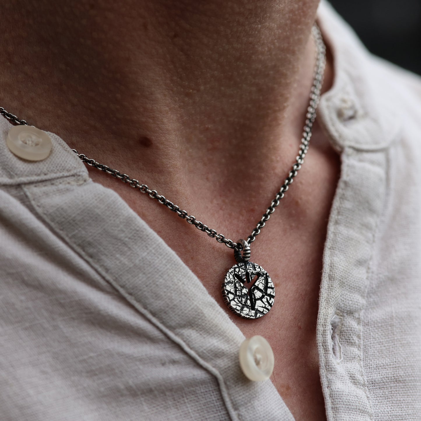 Close-up of textured Algiz Rune Pendant Necklace.