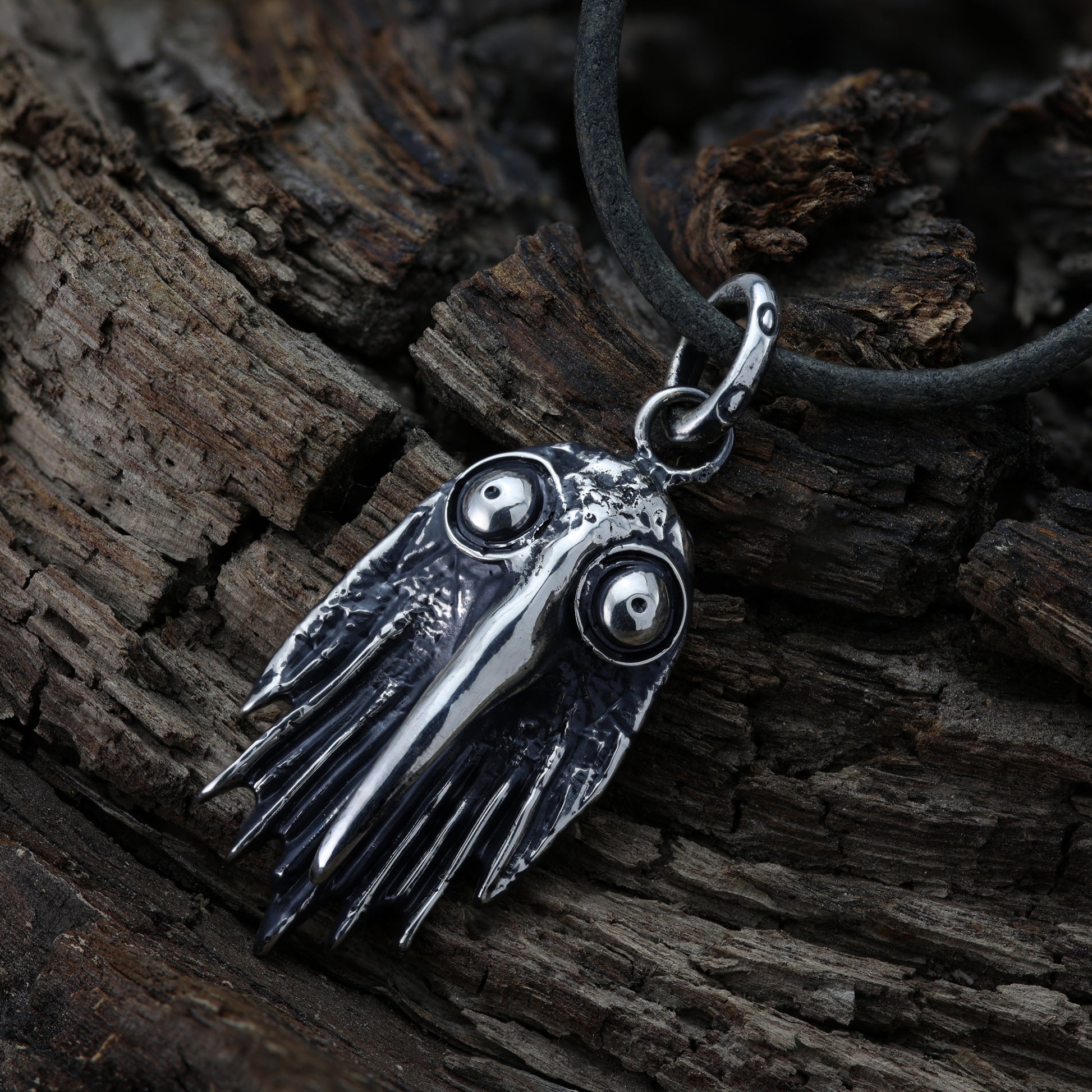 Close-up of darkened silver raven head, highlighting its polished beak and eyes