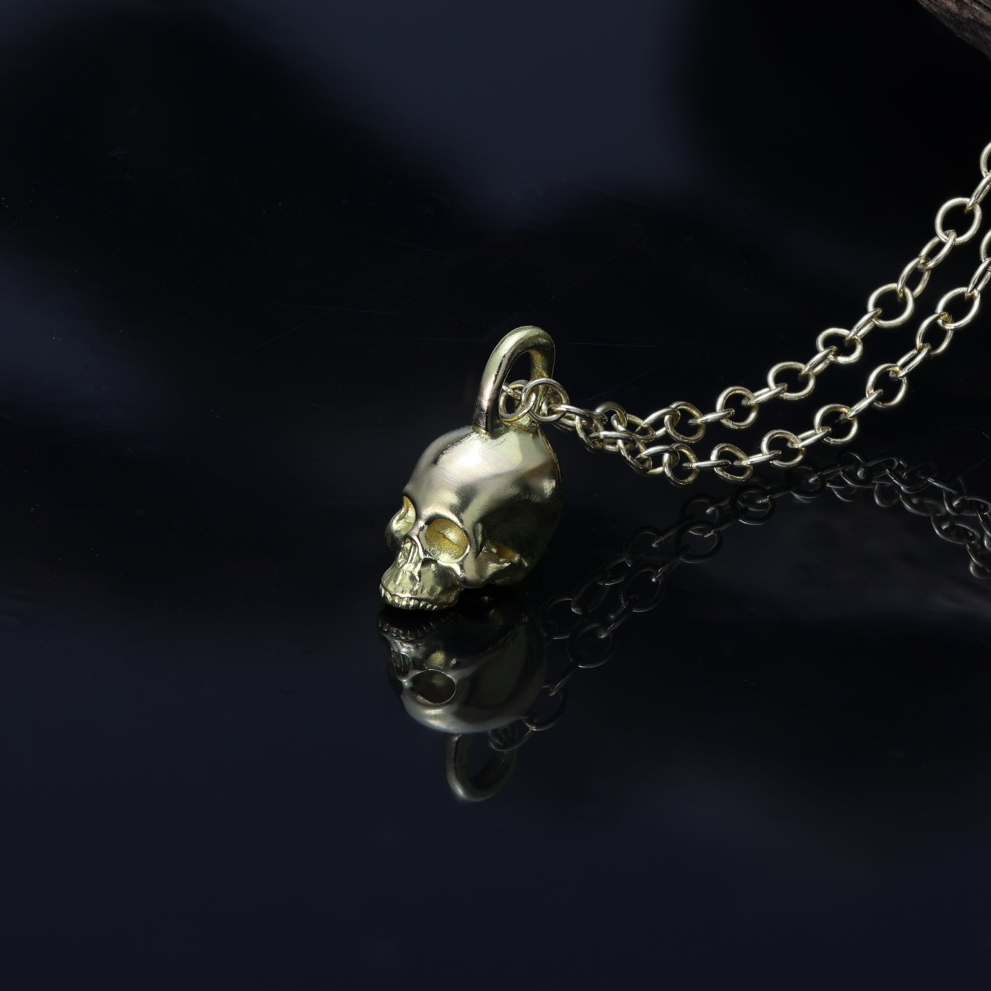 alt="Tiny skull pendant in 18-carat gold, representing the intersection of elegance, craftsmanship, and cultural symbolism."