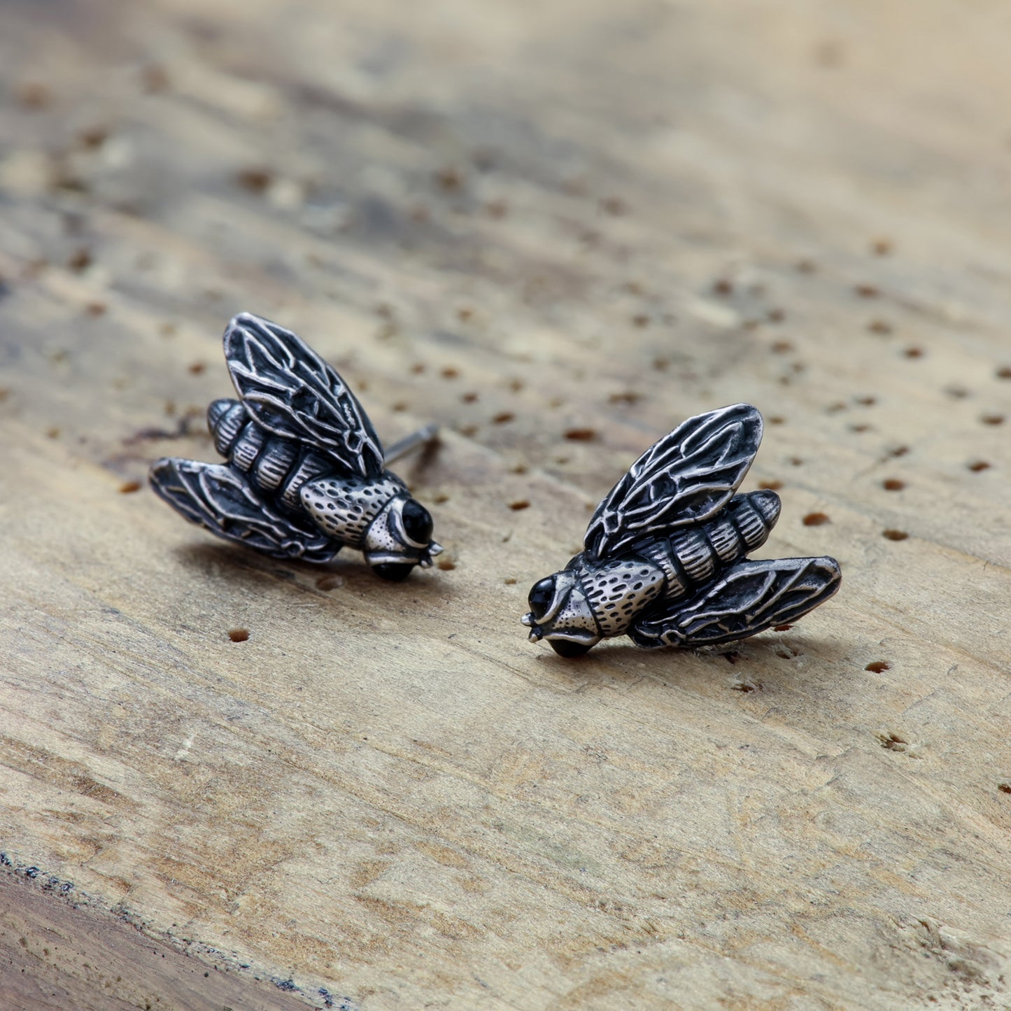 Artistic fly-shaped earrings made of sterling silver and enamel, a playful accessory.