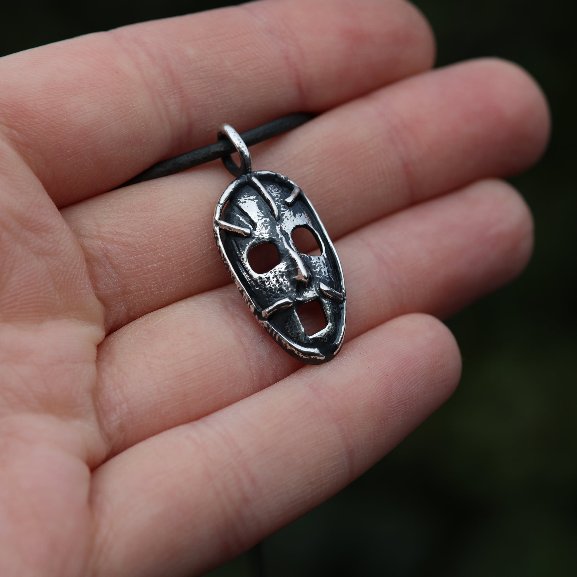 Hand holding the 'Prison of the Mind' pendant, reflecting the personal connection between the wearer and the artistic concept of mental entrapment and liberation.