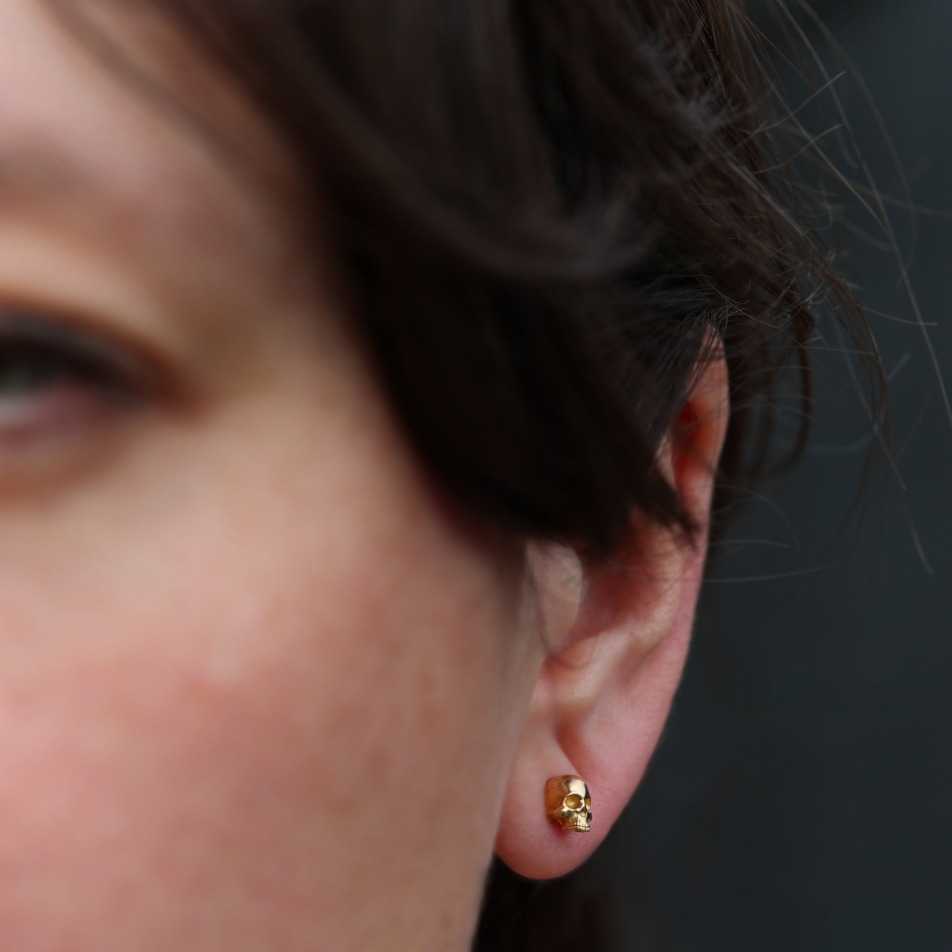 18 carat skull earrings in ear