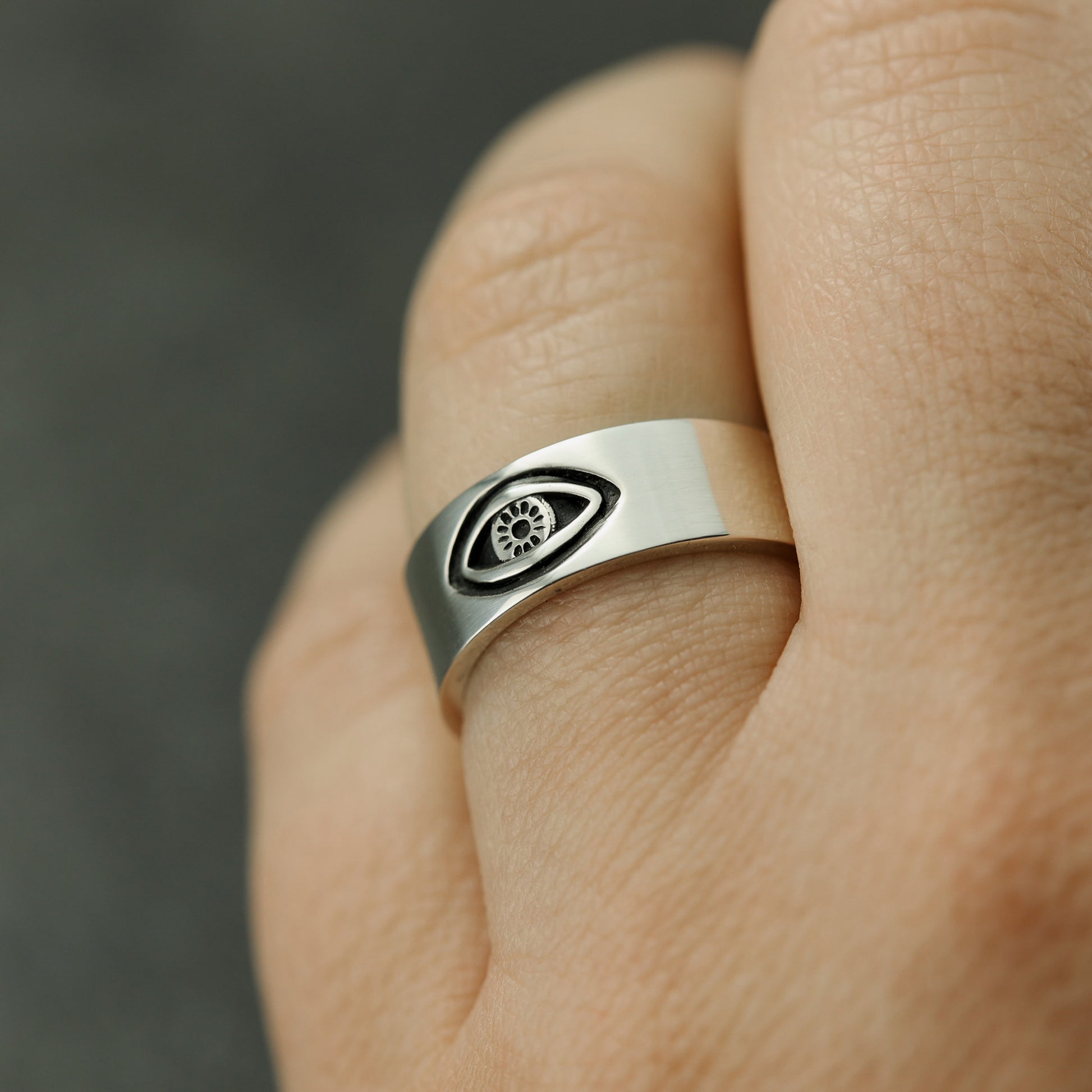 Evil eye ring on finger.