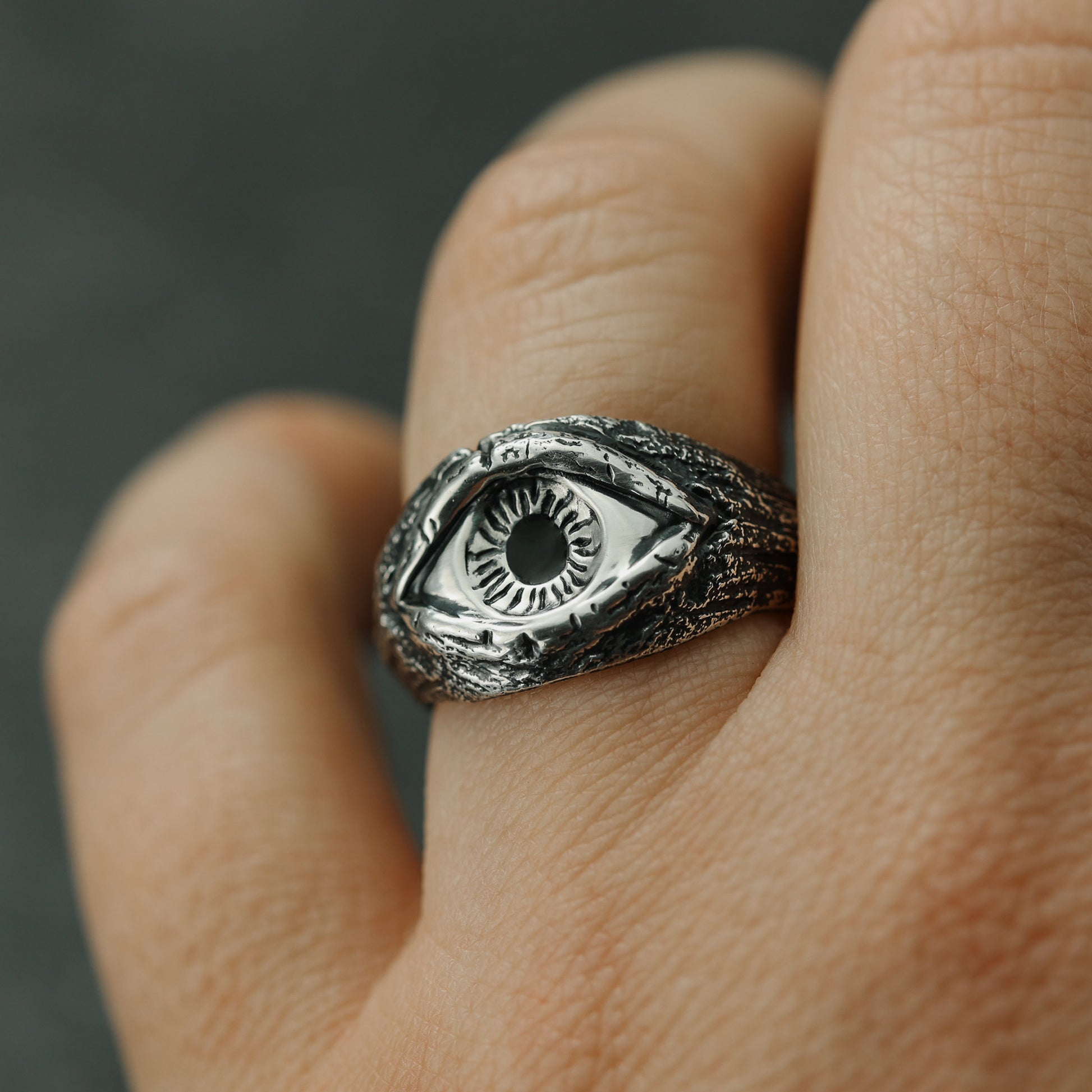 Closeup of the mesmerizing all-seeing eye motif on a sterling silver ring.