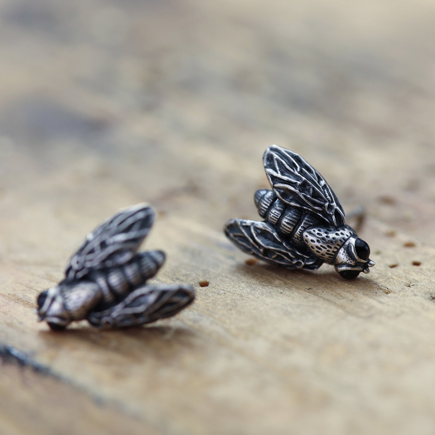 Sterling silver earrings featuring intricate fly motif.