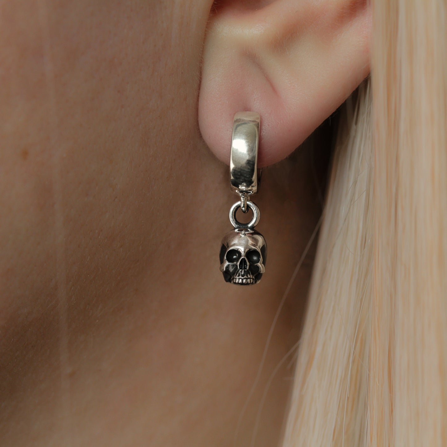 Skull hoop earring in ear