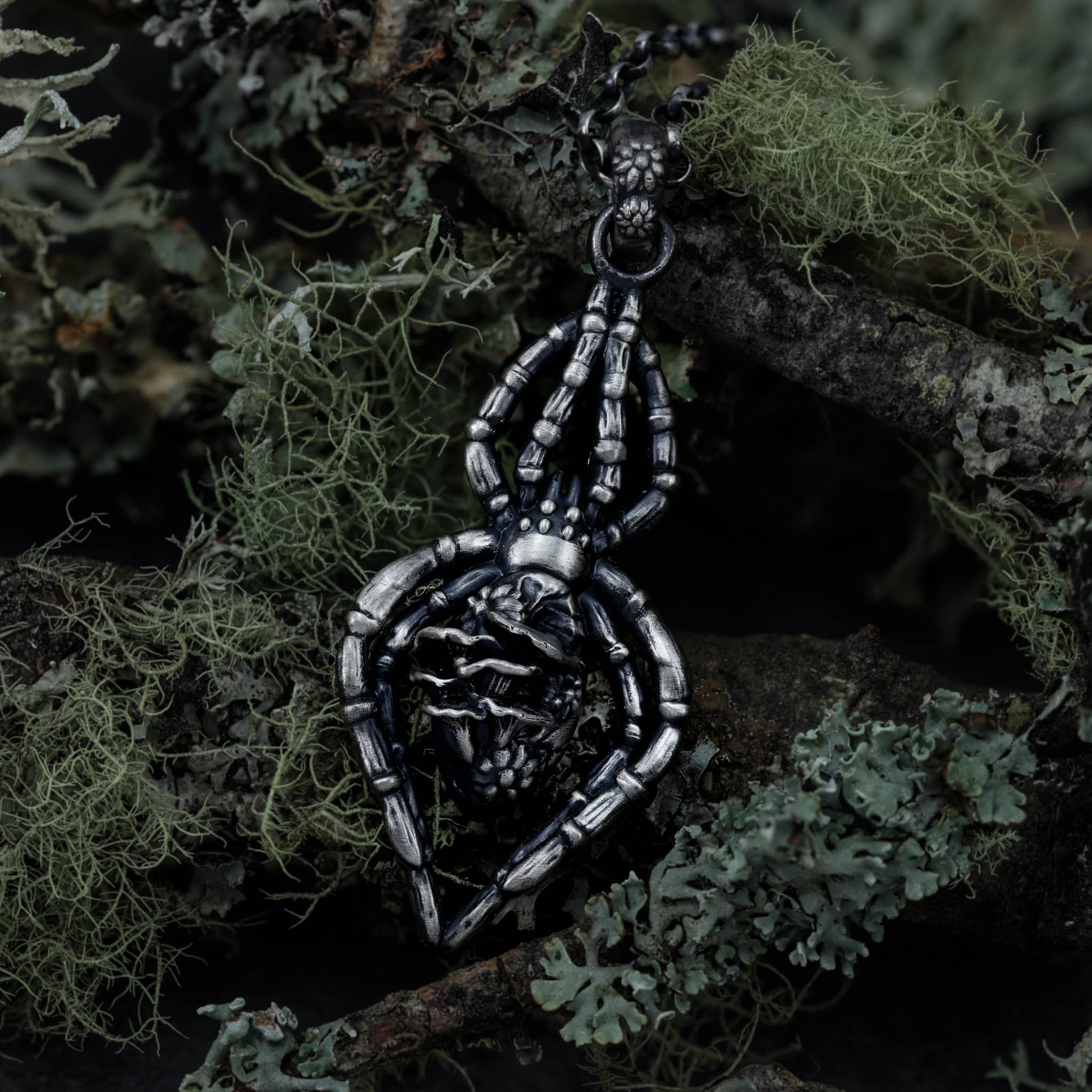 A unique and intricate spider necklace, expertly cast from sterling silver and decorated with floral and mushroom details, perfect for anyone who loves witchy and fantastical things..