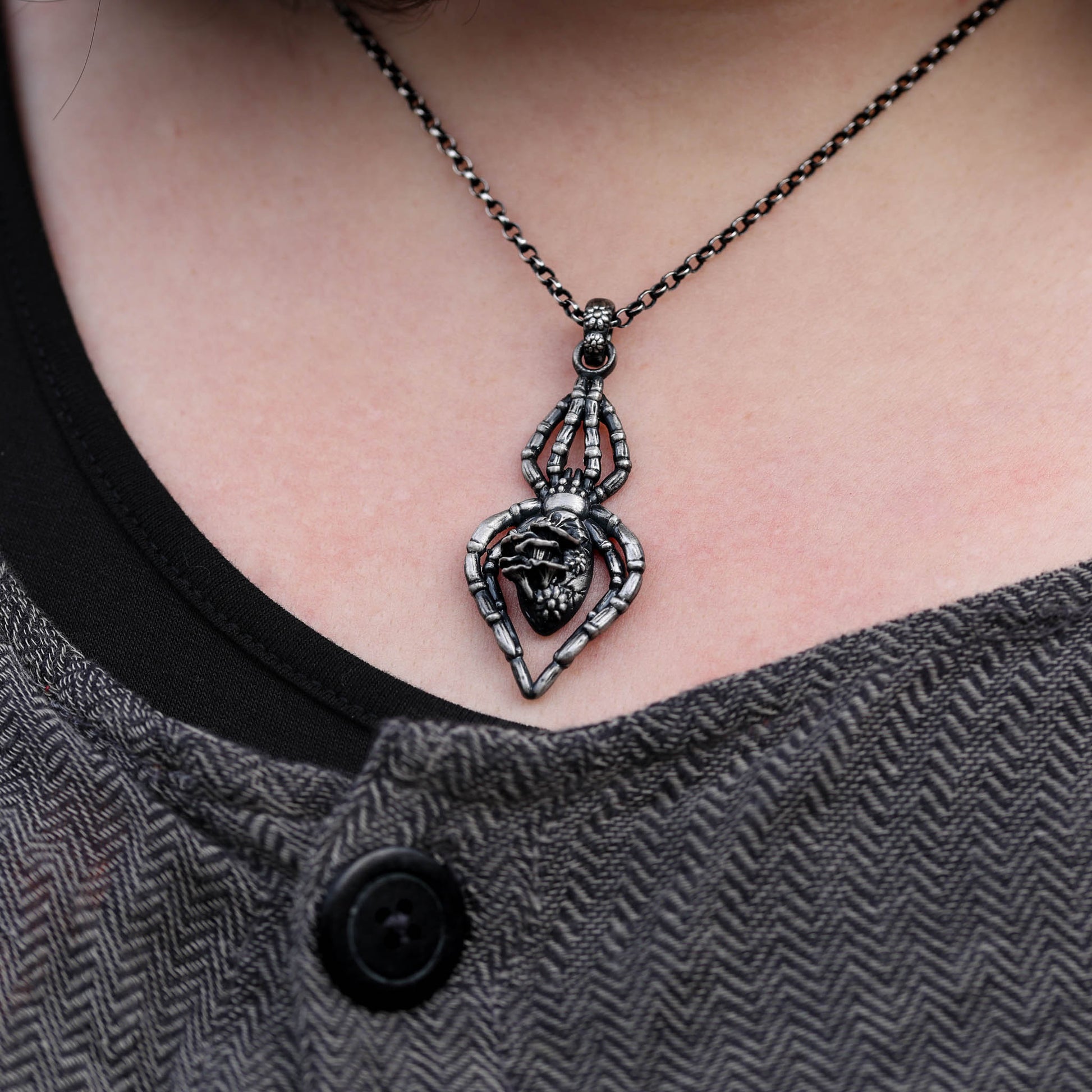 A unique and intricate spider necklace, expertly cast from sterling silver and adorned with floral and mushroom details, perfect for anyone who appreciates the beauty of the forest and the allure of witchcraft.