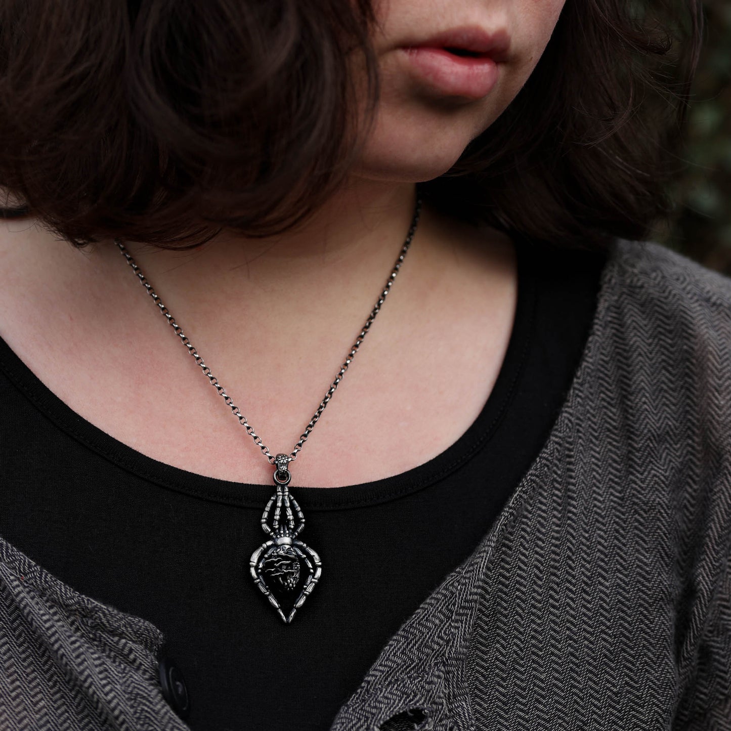 A beautifully crafted spider pendant made from sterling silver, featuring delicate mushrooms and flowers in its design, ideal for those who love the magic and enchantment of the woods.