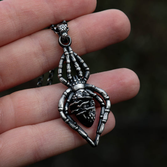 A highly detailed sterling silver spider necklace adorned with mushrooms and flowers, perfect for those who love witchy and taxidermy-inspired things.