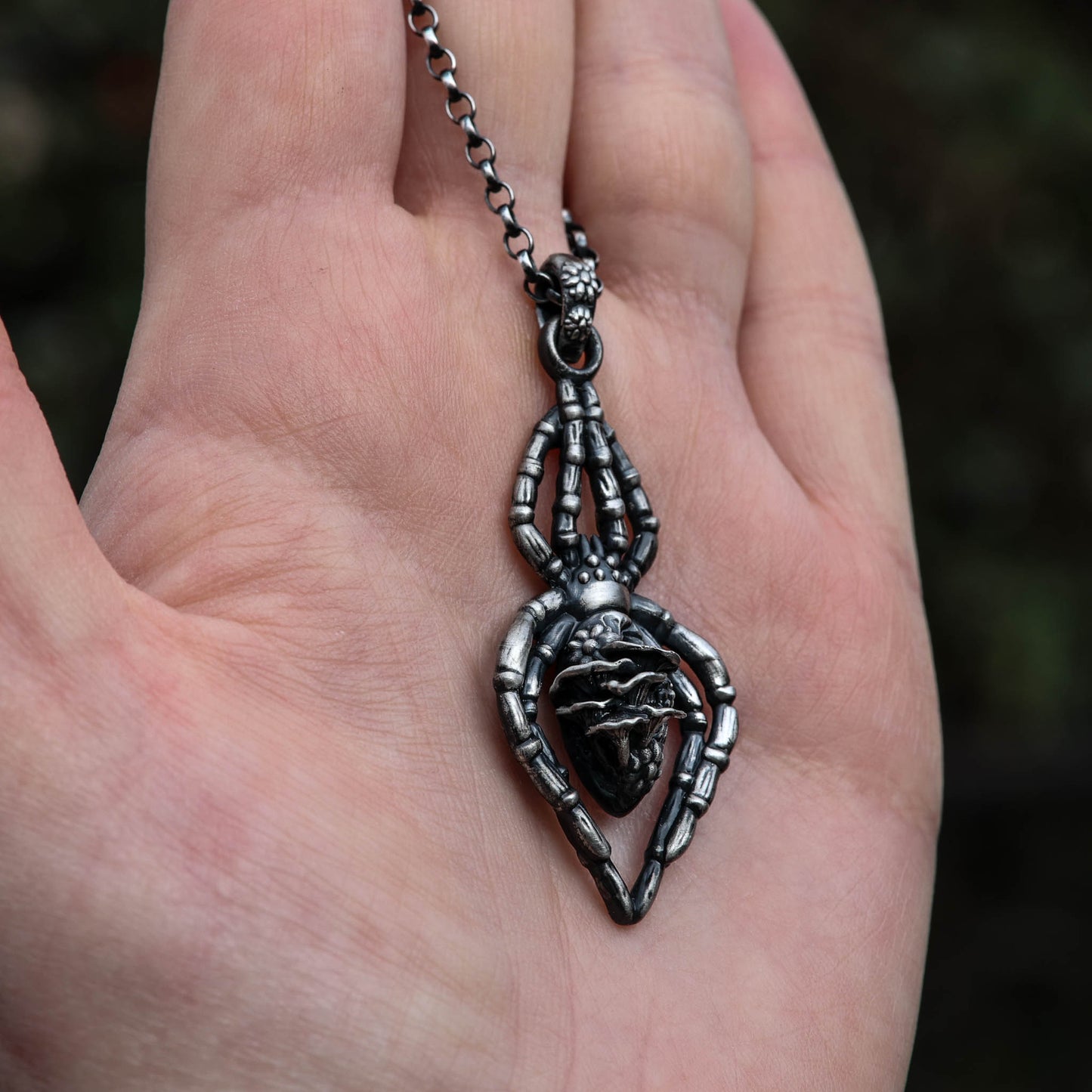 A stunning sterling silver spider necklace, decorated with intricate floral and mushroom details, perfect for anyone who loves the whimsy of the forest and witchy things.